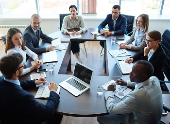 several office workers sitting around a table having a meeting