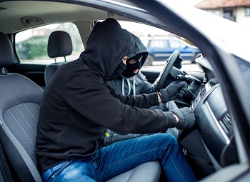 Two car thieves jamming the ignition of a vehicle