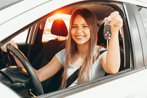 young female driver holding keys to car